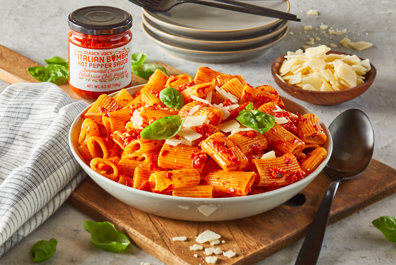 Trader Joe's Italian Bomba Hot Pepper Sauce; shown tossed with rigatoni pasta and garnished with shaved Parmesan Reggiano and fresh basil leaves