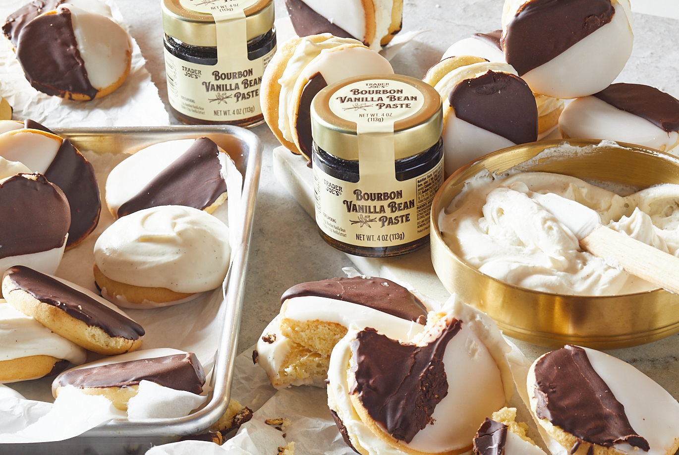 Trader Joe's Bourbon Vanilla Bean Paste; used in recipe for Vanilla Bean Cream frosting; in a gold bowl and between Half Moon cookie sandwiches in baking tray and on parchment