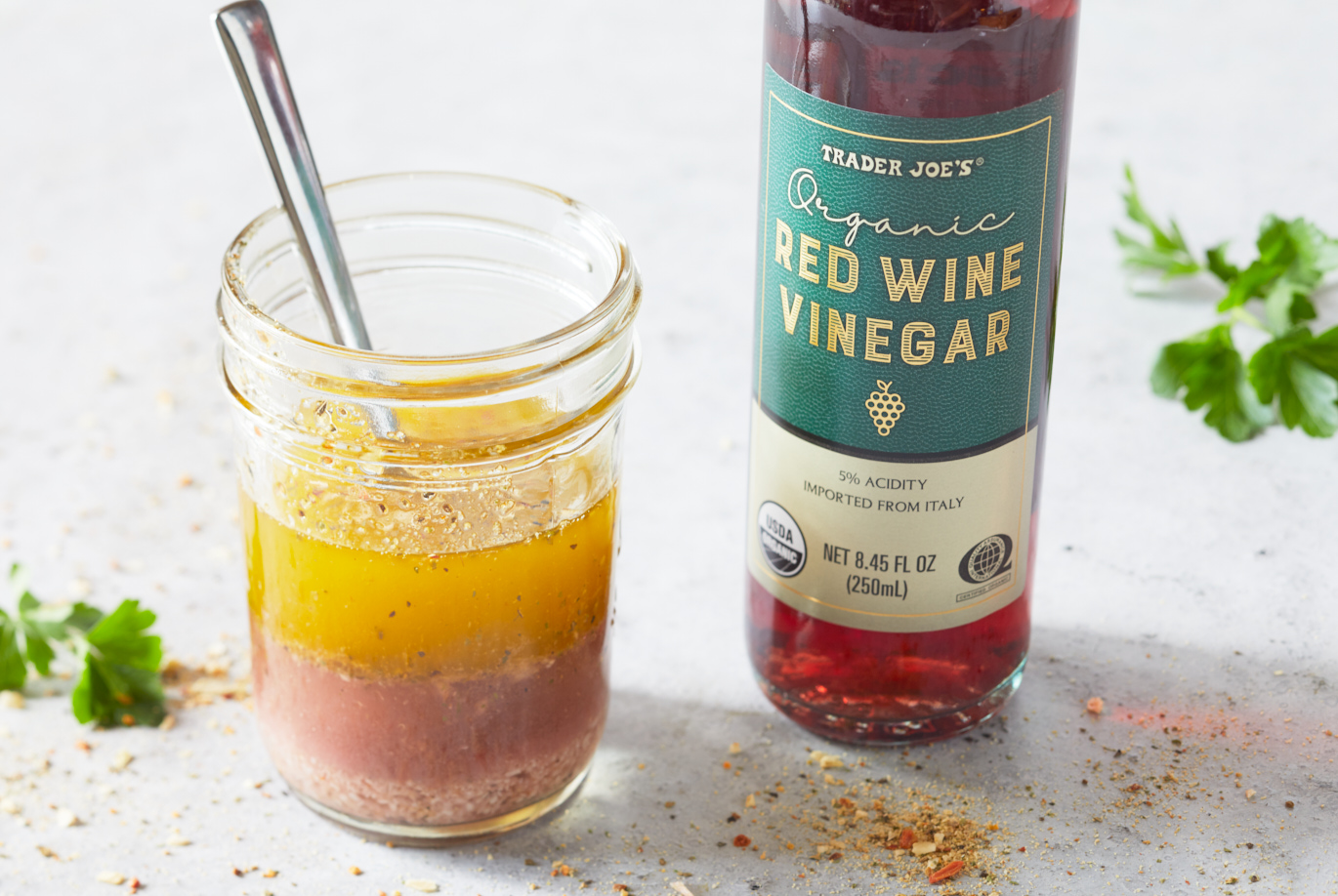 Trader Joe's Organic Red Wine Vinegar shown in recipe of 21 Seasoning Salute Vinaigrette; with spices and fresh parsley on surface