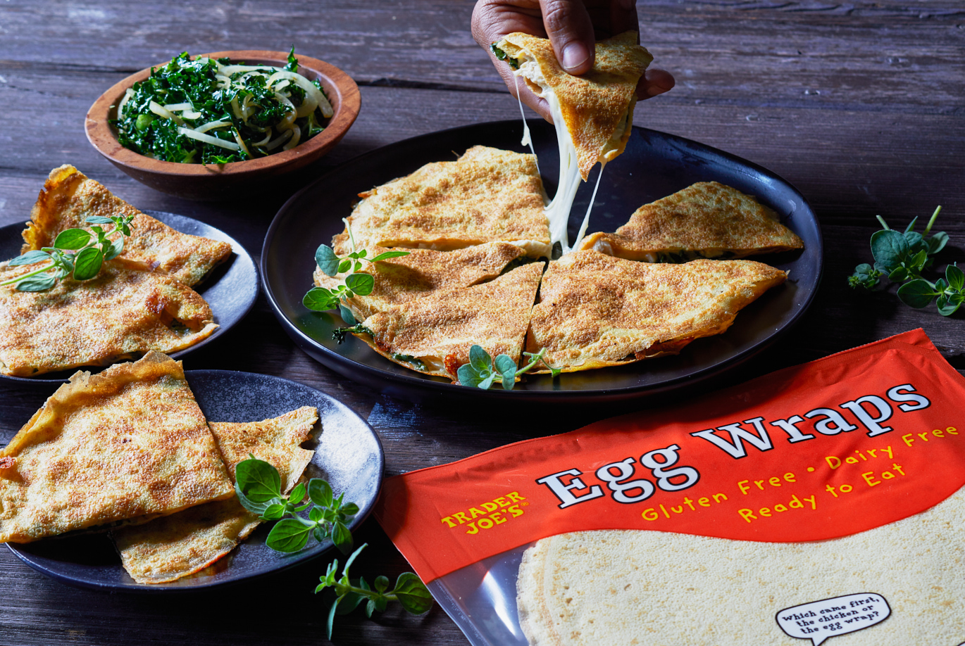Trader Joe's Egg Wraps used in 'No Tortilla Quesadilla' recipe; on a plate sliced into triangles, a hand pulling one slice up to show cheese pull
