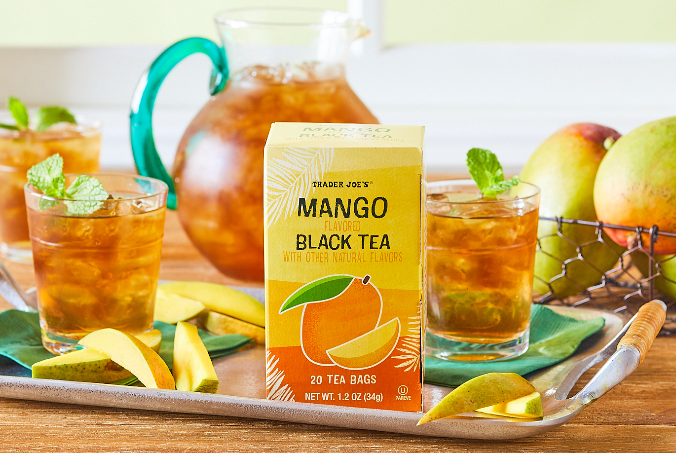 Trader Joe's Mango Black Tea; on a silver tray, in glasses topped with mint garnish, slices of fresh mango surrounding