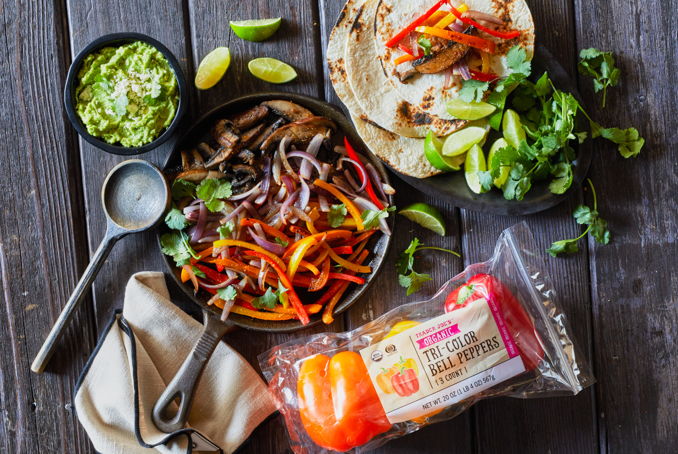 Trader Joe's Organic Tri-Color Bell Peppers; used in recipe for veggie fajitas; shown in fajita pan, with side of flour tortillas and small dish of guacamole