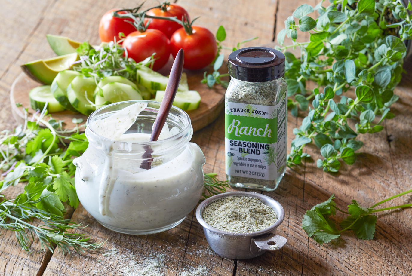 Trader Joe's Ranch Seasoning Blend; in a small measuring cup, and in a jar of fresh buttermilk ranch dressing recipe; vegetables in background
